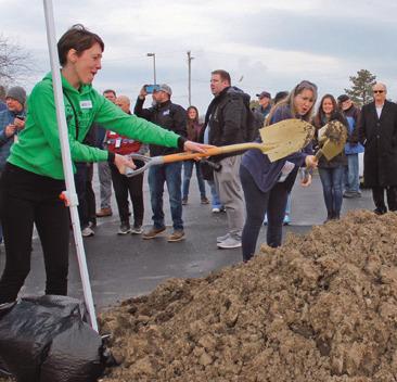 Employee Hailey Schurr is among employees, volunteers and guests invited to toss a shovel of dirt during the ground-breaking ceremony.