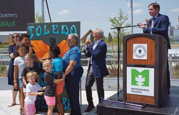 Metroparks Toledo board President, Scott Savage, invites children to join the park board commissioners in flipping a switch and “turning on” the new park.